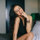 Aurela Skandaj, women, model, smiling, finger in mouth, sitting, closed eyes, black dresses wallpaper